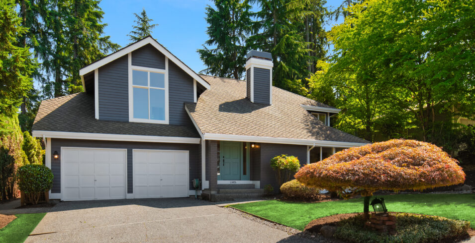 Driveway and two car garage of Highland Pointe Kirkland home with lawn and sculpted ornamental tree