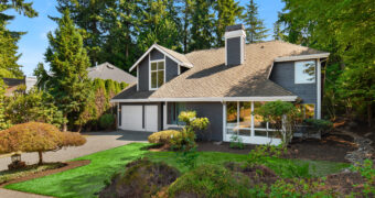 Street view of Kirkland Highlands home with rockery, evergreens, and landscaped front yard