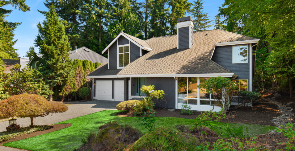 Street view of Kirkland Highlands home with rockery, evergreens, and landscaped front yard