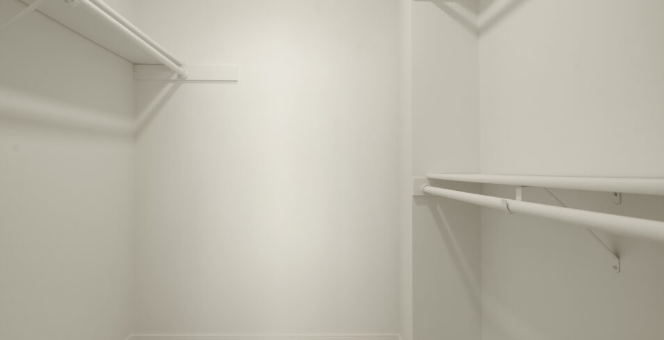 Walk in closet with white shelving and fresh paint in Kirkland Highlands home