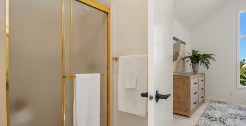 Primary suite bathroom with framed glass shower next to bedroom in Kirkland Highlands home