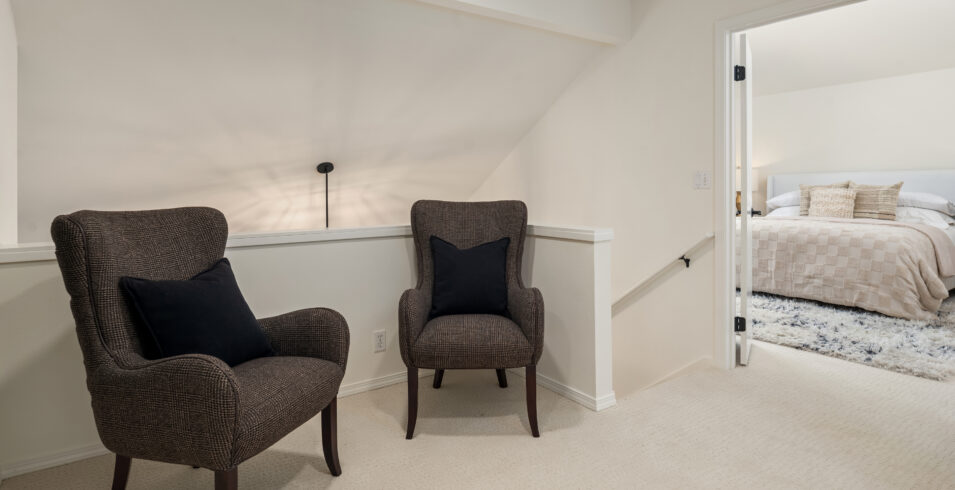 Upstairs landing sitting nook with two chairs outside primary bedroom in Kirkland home