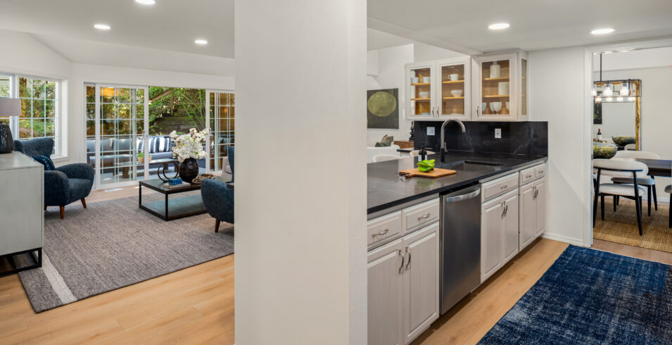 Kitchen with black quartz counters, white cabinets, and new flooring in Kirkland Highlands home