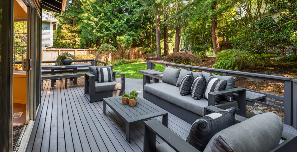 Long view of restored deck with outdoor dining and lounge seating in Kirkland Highlands home