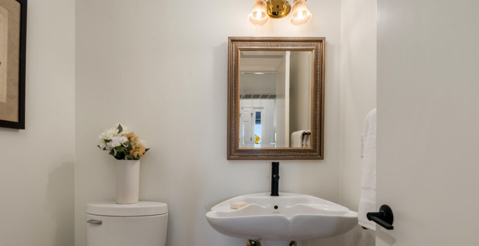 Powder room with pedestal sink and new black faucet in Kirkland Highlands home