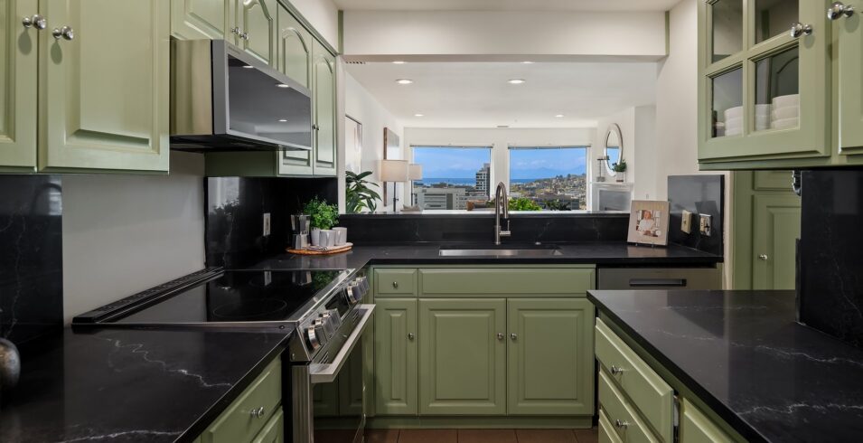 Kitchen with sage cabinetry, quartz counters and a full slab backsplash