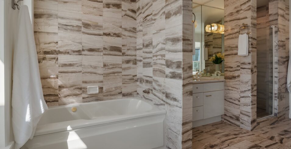 Soaking tub and tiled shower in the upper bath